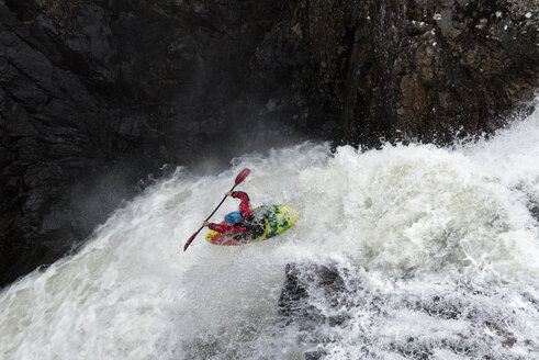 Mann fährt Kajak auf Wasserfall auf Fluss - ALRF01433