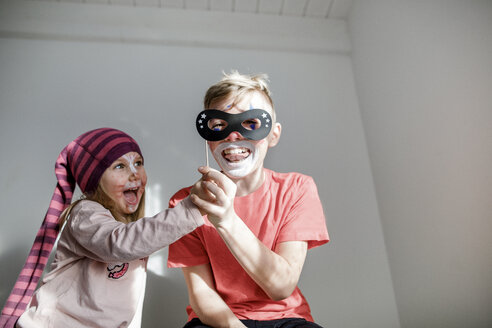 Bruder und kleine Schwester schminken sich für Karneval und haben Spaß zusammen - KMKF00786