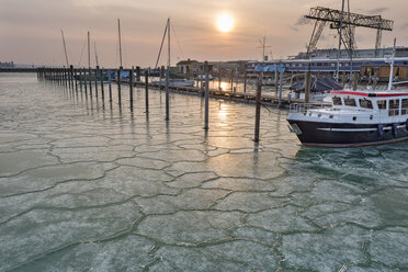 Deutschland, Baden-Württemberg, Bodensee, Konstanz, Eisschollen um Schiff und leere Stege mit Delfinen im Hafen bei Sonnenaufgang - SH02096