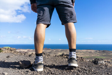 Spain, Canaray Islands, Fuerteventura, legs of a man standing at the coast - AFVF02564