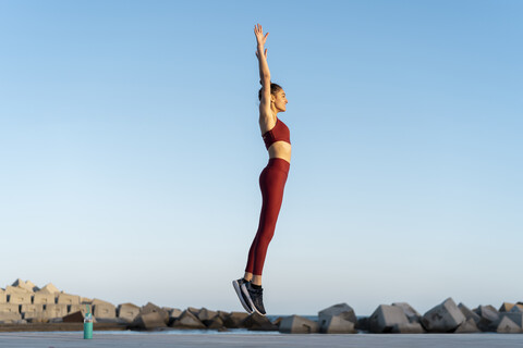 Sportliche junge Frau beim Workout, springend, lizenzfreies Stockfoto
