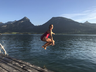 Austria, Salzburg, Salzkammergut, Salzburger Land, Wolfgangsee, St. Wolfgang, woman jumping into refreshing lake - GWF05985