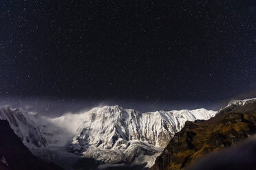 Scenic view of snowcapped mountains against star field at night - CAVF62785