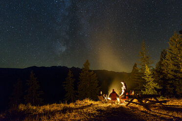 Friends camping on mountain against star field at night - CAVF62795