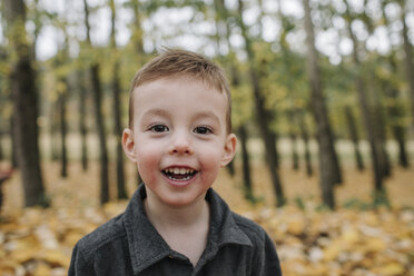 Porträt eines niedlichen, fröhlichen Jungen im Wald im Herbst - CAVF62803