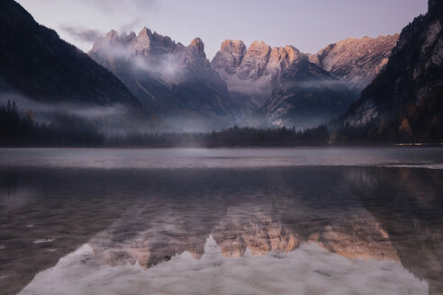 Malerischer Blick auf die Berge, die sich auf dem ruhigen See gegen den Himmel bei Sonnenaufgang spiegeln - CAVF62880