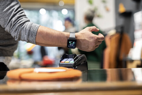 Customer paying contactless with his smartwatch - PESF01529