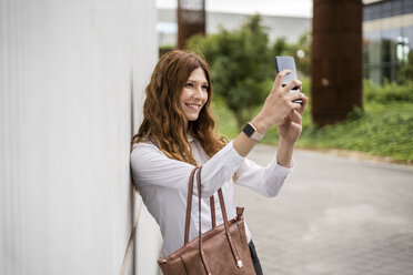 Young businesswoman commuting in the city, taking selfies - GIOF05805