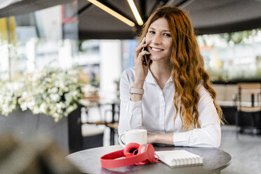 Young businesswoman sitting in cafe, talking on the phone - GIOF05834