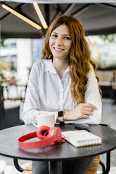 Young businesswoman sitting in cafe, smiling - GIOF05835