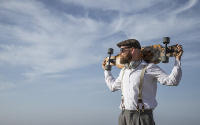 Bearded man with longboard on his shoulders looking at distance - KBF00580