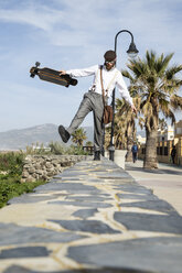 Man with longboard balancing on a wall - KBF00588