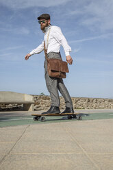 Bärtiger Mann mit Ledertasche auf Longboard - KBF00589