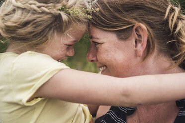 Close-up of happy mother carrying daughter while standing in forest - CAVF62900