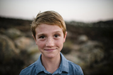 Close-up portrait of smiling boy on field during sunset - CAVF62980