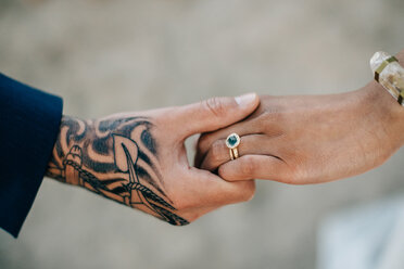 Braut und tätowierter Bräutigam halten sich an den Händen, Ausschnitt - ISF20956