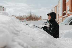 Man laughing beside snow-covered vehicle, Toronto, Canada - ISF20960