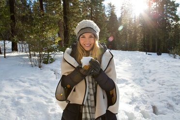 Junge Frau mit Schneeball im Winterwald, Porträt, Twain Harte, Kalifornien, USA - ISF20963