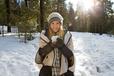 Young woman holding snowball in winter forest, portrait, Twain Harte, California, USA - ISF20963