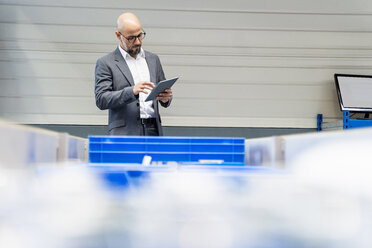 Businessman with tablet checking stock in factory - DIGF06127