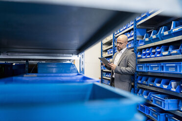 Businessman with tablet in factory storehouse - DIGF06133