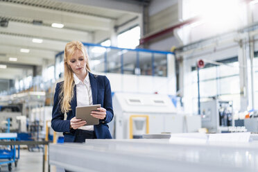 Geschäftsfrau benutzt Tablet in einer Fabrik - DIGF06140