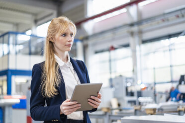 Businesswoman holding tablet in factory - DIGF06142