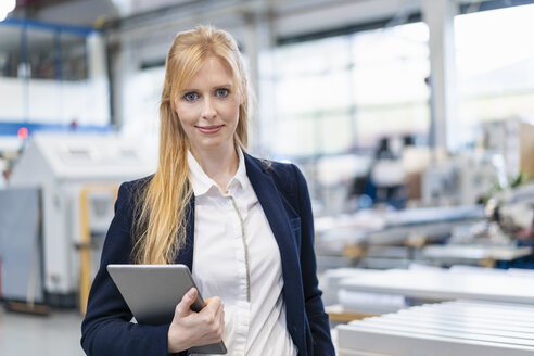Portrait of confident businesswoman with tablet in factory - DIGF06143
