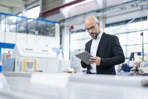 Geschäftsmann benutzt Tablet in einer Fabrik - DIGF06144