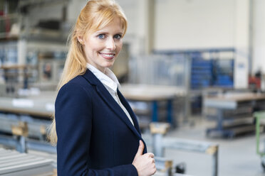 Portrait of smiling businesswoman in factory - DIGF06155