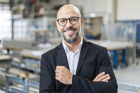Porträt eines lächelnden Geschäftsmannes in einer Fabrik - DIGF06158