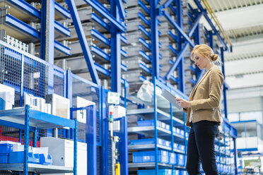 Businesswoman with tablet in factory storehouse - DIGF06163