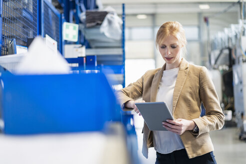 Businesswoman with tablet in factory storehouse - DIGF06164