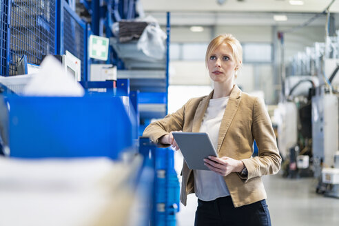 Businesswoman with tablet in factory storehouse - DIGF06165