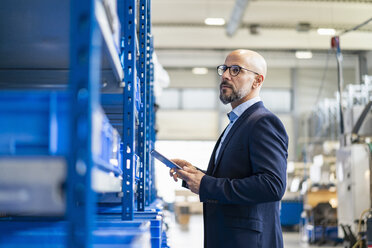 Businessman with tablet in factory storehouse - DIGF06169