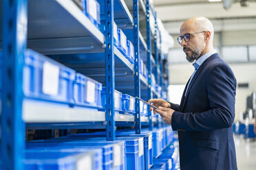 Businessman with tablet in factory storehouse - DIGF06170