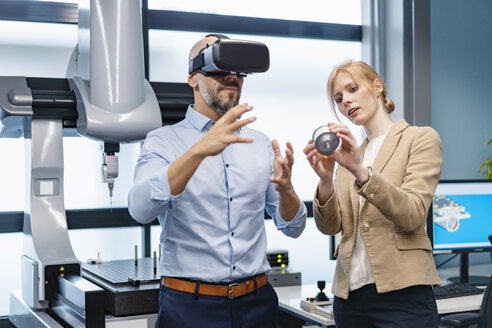 Businessman and businesswoman withVR glasses and workpiece in factory - DIGF06171