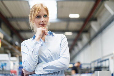 Portrait of businesswoman in factory thinking - DIGF06176