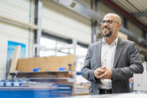 Glücklicher Geschäftsmann in einer Fabrik, lizenzfreies Stockfoto