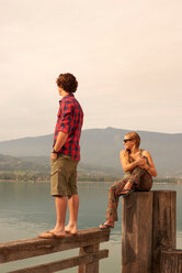 Young couple looking out from pier, Lake Annecy, Annecy, Rhone-Alpes, France - CUF49523