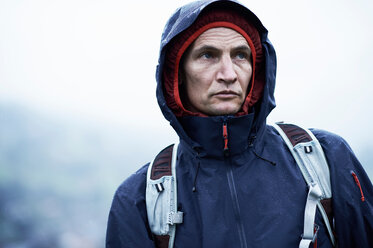 Älterer männlicher Wanderer im Anorak mit Kapuze im Regen, Manigod, Rhone-Alpes, Frankreich - CUF49537