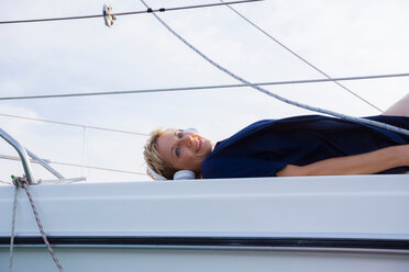 Reife Frau beim Sonnenbad auf Segelboot auf Chiemsee, Porträt, Bayern, Deutschland - CUF49621