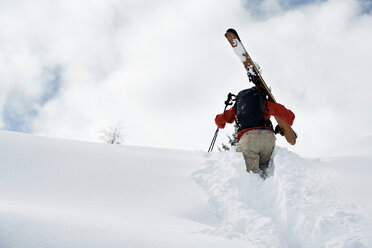 Männlicher Skifahrer stapft den schneebedeckten Berg hinauf, Rückansicht, Alpe-d'Huez, Rhone-Alpes, Frankreich - CUF49646