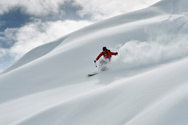 Männlicher Skifahrer, der einen schneebedeckten Berg hinunterfährt, Alpe-d'Huez, Rhone-Alpes, Frankreich - CUF49649