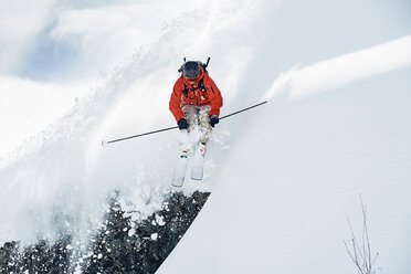 Männlicher Skifahrer fährt mitten in der Luft einen schneebedeckten Berg hinunter, Alpe-d'Huez, Rhone-Alpes, Frankreich - CUF49655