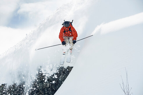 Männlicher Skifahrer fährt mitten in der Luft einen schneebedeckten Berg hinunter, Alpe-d'Huez, Rhone-Alpes, Frankreich - CUF49655