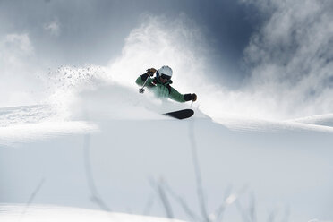 Männlicher Skifahrer, der einen schneebedeckten Berg hinunterfährt, Alpe-d'Huez, Rhone-Alpes, Frankreich - CUF49656