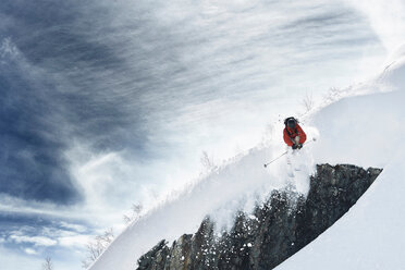 Männlicher Skifahrer fährt mitten in der Luft einen steilen, schneebedeckten Berg hinunter, Alpe-d'Huez, Rhone-Alpes, Frankreich - CUF49660