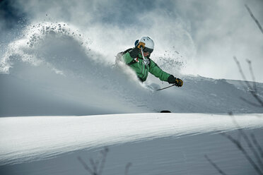 Male skier skiing on snow covered mountain, Alpe-d'Huez, Rhone-Alpes, France - CUF49661