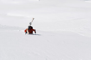 Male skier trudging up mountain through deep snow, Alpe-d'Huez, Rhone-Alpes, France - CUF49667